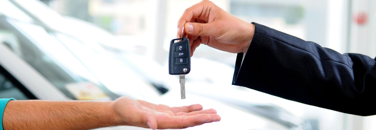 Business man handing a customer a set of car keys.